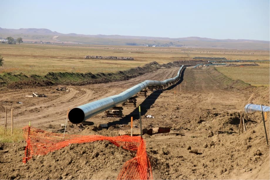 Tubería de Diámetros Mayores instalada en un terreno rural, rodeada de tierra removida y con un fondo de pradera.