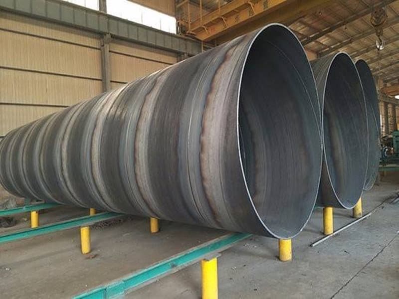 Tubería de Diámetros Mayores de acero, grandes y con un acabado soldado, almacenadas en un taller industrial.